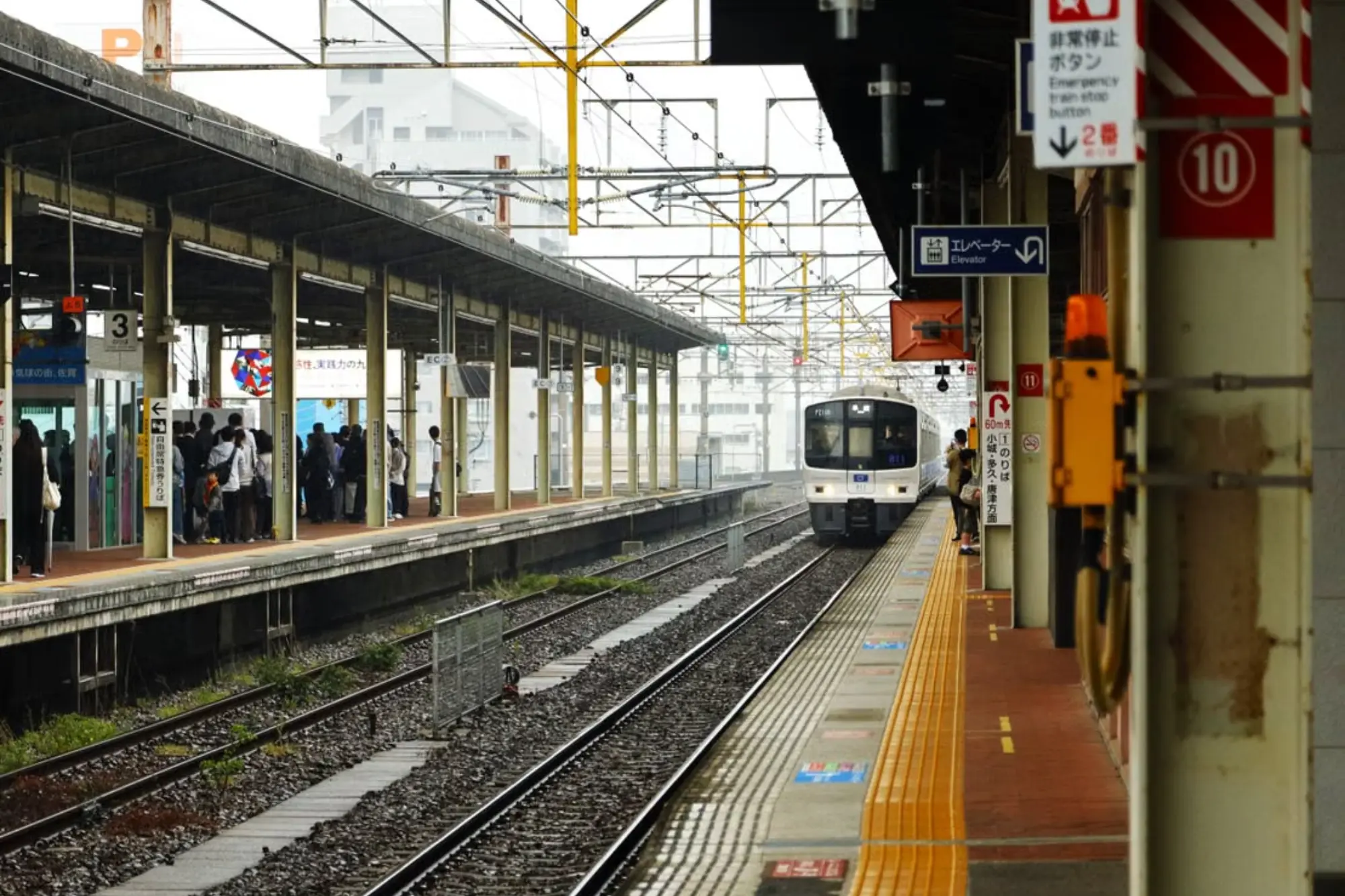 A JR train pulling into a clean railway station platform