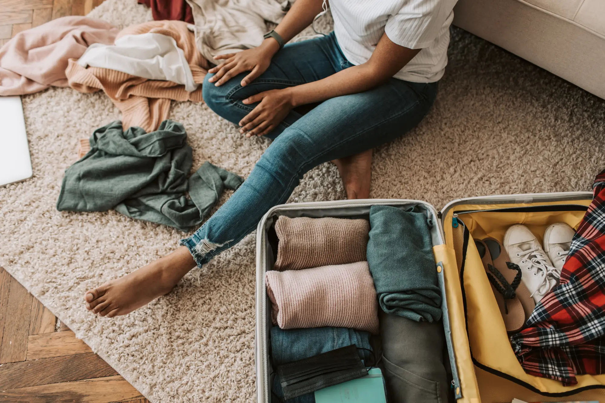 Overpacked suitcase overflowing with clothes